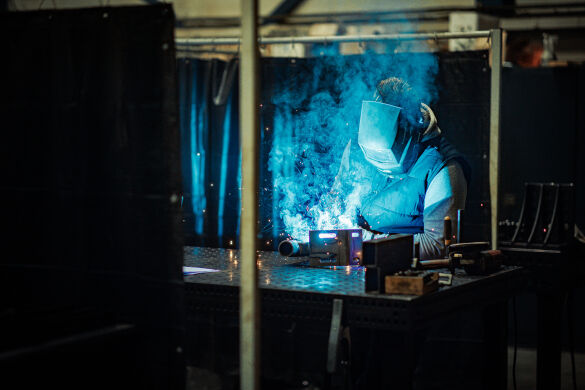 Lasser aan het werk met een staalconstructie voor een bedrijfshal